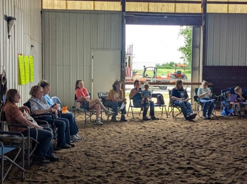 Owners gathered at an EquiStroke hands-on session in a barn arena